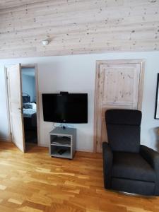 南雪平Semesterhus med spabad & bastu的客厅配有椅子和平面电视