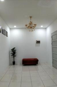 Kota SamarahanHomestay @Seri Sindang Guesthouse的一间设有红色沙发的房间,房间配有吊灯