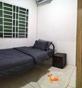 Kota SamarahanHomestay @Seri Sindang Guesthouse的卧室配有床,地毯上有一只玩具马