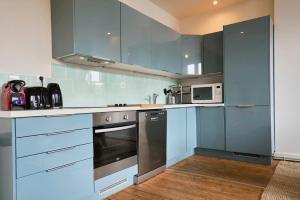 里尔Lille hypercentre-2 bedrooms very bright + parking的厨房配有不锈钢用具和蓝色橱柜