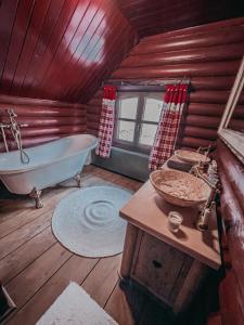 诺茨瓦约Rönkház Noszvaj的小屋内设有一间带浴缸和水槽的浴室