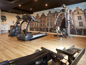 阿拉斯水星阿特里亚阿拉中央酒店的健身房设有两台跑步机和壁画