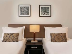 苏瓦诺富特苏瓦拉米湾酒店的两张床位于酒店客房,配有床头灯