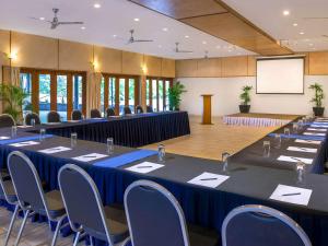 苏瓦诺富特苏瓦拉米湾酒店的一间会议室,配有桌椅和屏幕