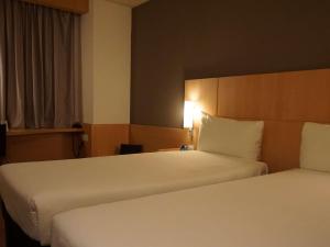 赫罗纳赫罗纳宜必思酒店的酒店客房,设有两张床和一盏灯
