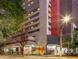 贝洛奥里藏特阿丰索佩纳宜必思美丽地平线酒店的一座高大的建筑,晚上有色彩缤纷的外观