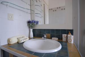 努奥罗Nughe 'e' Oro Guesthouse的浴室设有白色水槽和镜子
