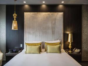 惠灵顿惠灵顿索菲特酒店的卧室配有一张带两个枕头的大白色床