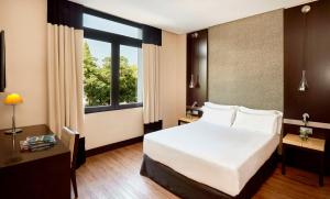 赫雷斯-德拉弗龙特拉NH阿维尼达赫雷斯酒店的卧室设有白色的床和大窗户