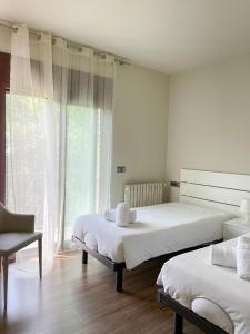圣保Can Baseia - amb jardí i accés privat a La Fageda的一间卧室设有两张床和窗户。