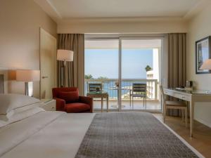 贝鲁特贝鲁特默维皮克酒店的酒店客房设有一张床、一张书桌和一个阳台。