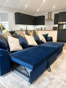 沃辛Luxury 3 Bedroom House的客厅配有带枕头的蓝色沙发