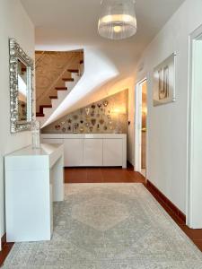奥蒂塞伊B&B Lavi Ortisei val Gardena的一间带楼梯的客厅和一间白色厨房
