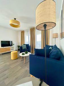 里尔Domitys L'Agapanthe的客厅配有蓝色的沙发和电视
