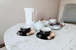 斯托诺韦卡巴菲德酒店 的桌子上放着两个杯子和茶具