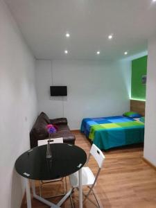马德里Apartamentos EconoStay Barbieri 1的客房设有桌子、床和桌椅。