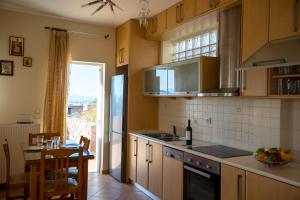 AegenitissaAegina Sea View Villa的厨房配有木制橱柜、餐桌和用餐室