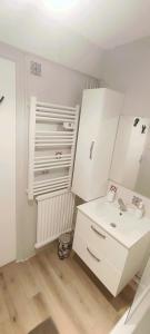 AureilhanLe Cocooning的一间带水槽和部分白色橱柜的浴室