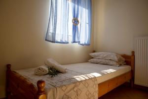 AegenitissaAegina Sea View Villa的一间卧室配有一张带蓝色窗帘的窗户的床
