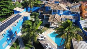 布希奥斯Pousada Laguna Búzios的享有棕榈树蓝色建筑的空中景致