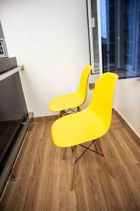 YenagoaLe Rivera Apartments的两把黄色椅子,位于木地板的房间