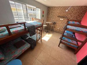 奥林达Hostel Simple的客房设有两张双层床和一张桌子。