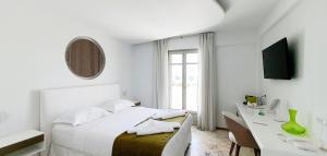 斯基罗斯岛Tzanis Resort Skyros的白色卧室配有床和书桌