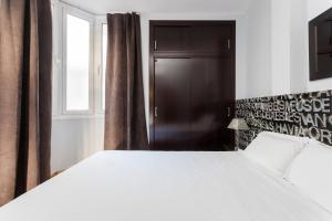 巴塞罗那最佳巴塞罗纳公寓的卧室设有一张白色大床和一扇窗户。