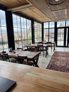 格雷梅Turan Cappadocia Cave的餐厅设有桌椅和大窗户。