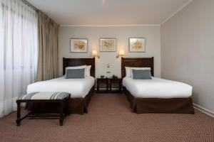 圣地亚哥Teclados Hotel的酒店客房设有两张床和窗户。