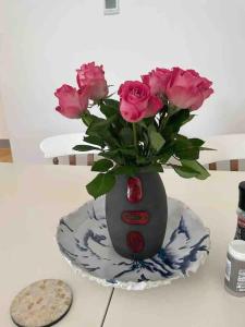 林肯Hendrix’s cottage的镶在盘子上的花瓶,上面装着粉红色的玫瑰花