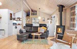 埃贝尔托夫特Awesome Home In Ebeltoft With Sauna的客厅设有真皮沙发和壁炉