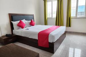 班加罗尔FabHotel KSP Kings Inn的一间卧室配有一张带红色枕头的大床