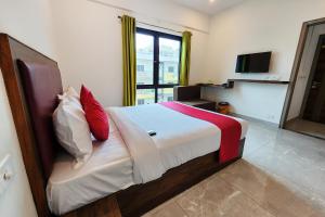 班加罗尔FabHotel KSP Kings Inn的一间卧室配有一张带红色和白色枕头的大床