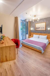 Solo Grand Boshuri Hotel Wellness Resort的一间卧室配有一张大床和一张红色椅子