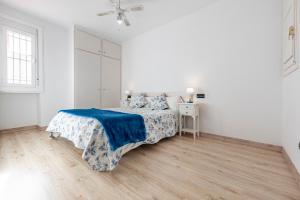 塔拉戈纳Bettatur Apartaments Via Imperi Romà的白色卧室配有一张带蓝色毯子的床