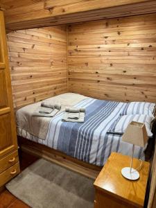 科维良Mountain Lodge T3 Duplex Abrigo do Lobo的一间卧室设有一张床和木墙
