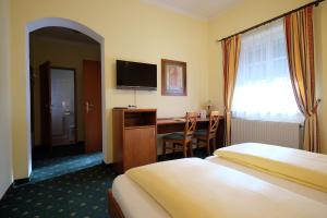瓦格纳Hotel Restaurant Neuhold的酒店客房设有两张床、一张桌子和一台电视。