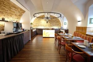 瓦格纳Hotel Restaurant Neuhold的一间带木桌椅的餐厅和一间酒吧