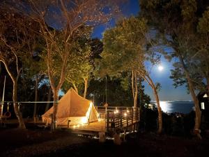 真鹤町COUSCOUS Glamping Manazuru的夜晚的帐篷,月亮在后面