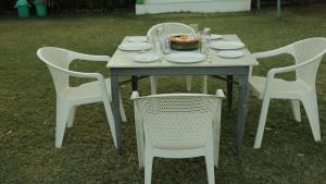 乌代浦Hill View Resort by Rudrakshi的一张桌子,上面有白色的椅子和一碗食物