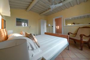 布拉卡尼Le Versegge Resort的一间卧室配有一张大床和一把椅子