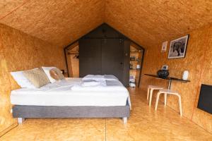 卡兰茨奥赫Tenthuisje met hottub in Callantsoog的一间卧室配有一张床,并在一间客房内配有电视。