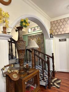 斯利那加Heritage Rose Inn的一间设有楼梯的房间,桌子上有一个花瓶