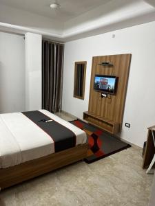 钦奈Gulnaar Inn的一间卧室配有一张床和一台平面电视