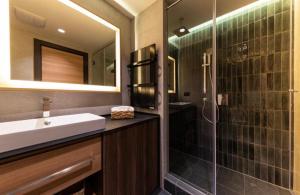 科帕奥尼克Woodside Apartment的浴室配有盥洗盆和带镜子的淋浴
