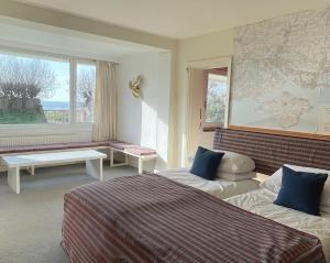 西威特灵West Wittering beach house with direct beach access的酒店客房设有两张床和大窗户。