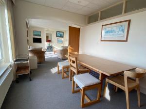 西威特灵West Wittering beach house with direct beach access的一间设有木桌和椅子的等候室