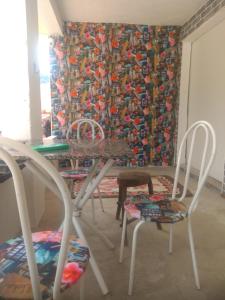 乌巴图巴Camping estrela Ubatuba的用餐室配有桌椅和窗帘