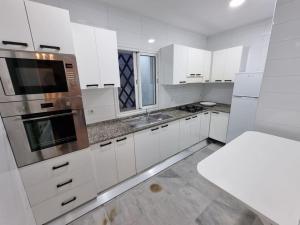 拉马萨Superbe appartement indépendant à l'entrée de la marsa的白色的厨房配有白色橱柜和水槽